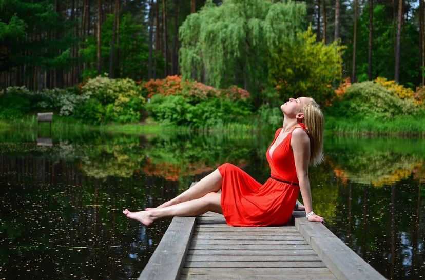 a woman relaxing by the lake, plants, trees