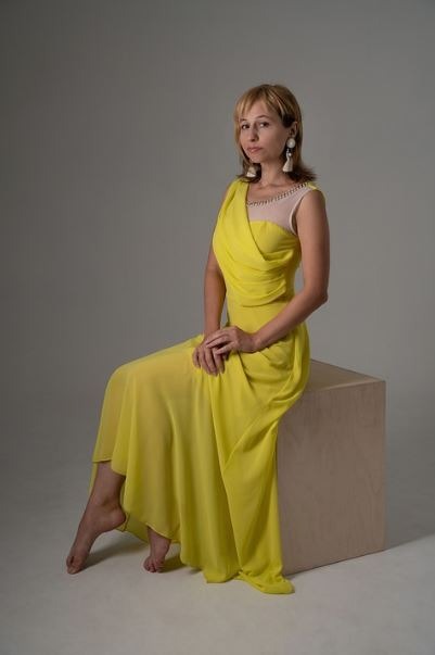 a sitting woman in a yellow dress