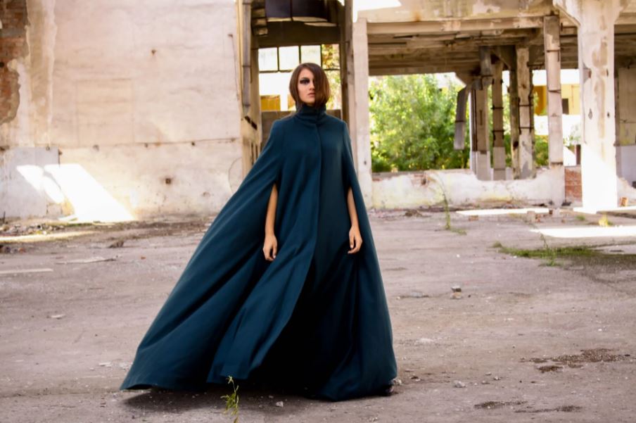 a woman wearing a cape dress