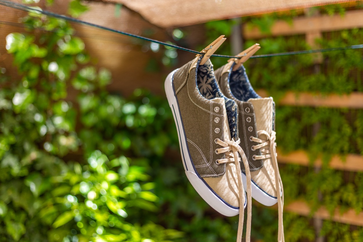 Madrid Spain. May 6, 2022. Canvas shoes hanging in the sun in the garden. Summer, vacation, resting.