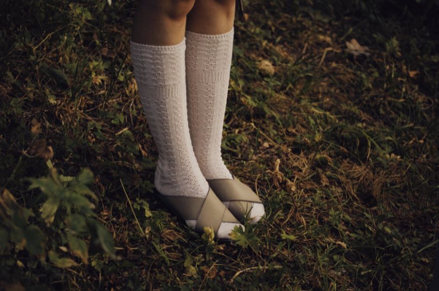 feet wearing white long socks and grey sandals