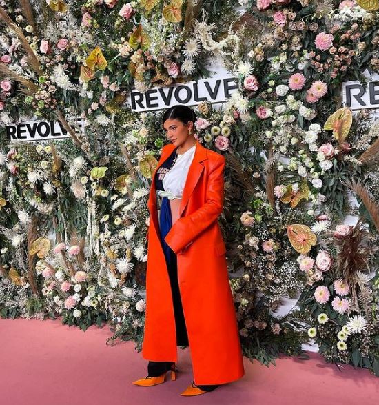 Kylie Jenner wearing a trench coat on the Revolve red carpet