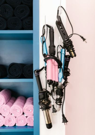 different types of curling irons hanging on the wall