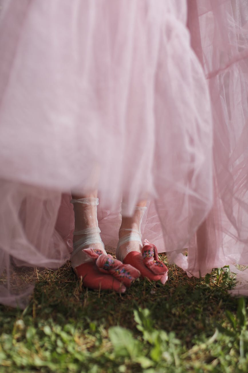 the feet of a woman in a dress wearing ballet flats
