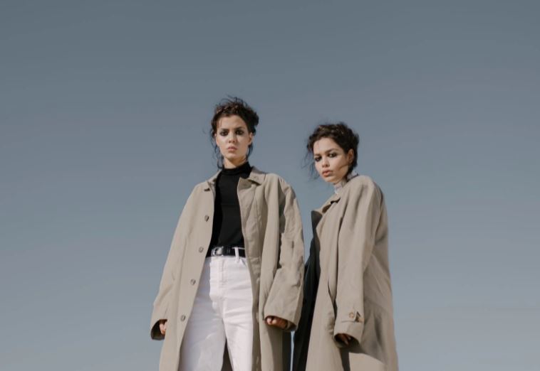 two women wearing trench coats standing next to each other