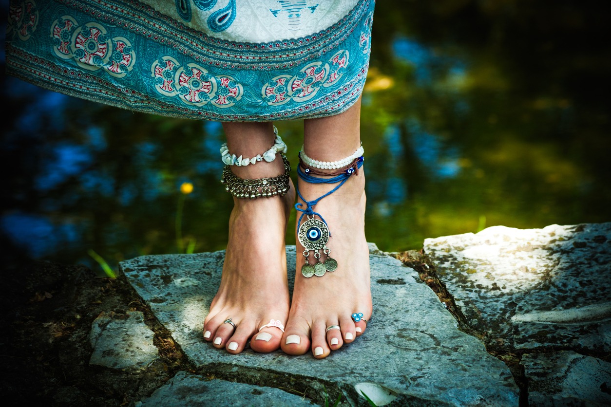a woman barefoot and on tiptoes wearing anklets and toe rings