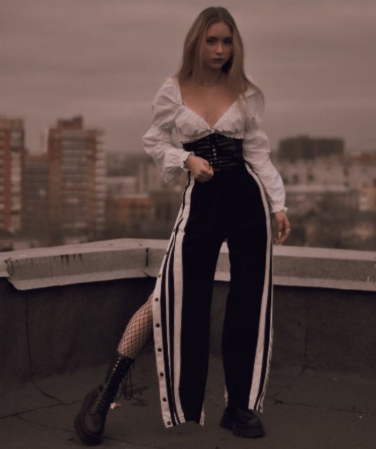 a woman on a rooftop wearing a black and white outfit