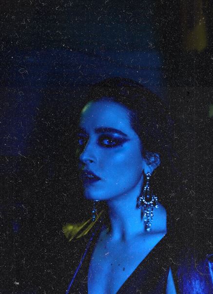 a woman under blue light with smokey eye makeup