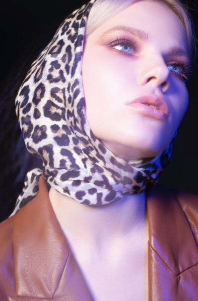 a woman wearing a leopard-printed headscarf