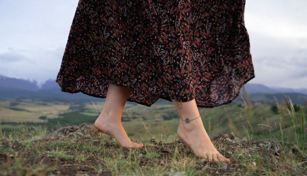 close-up photo of a woman wearing a dress' feet with an anklet