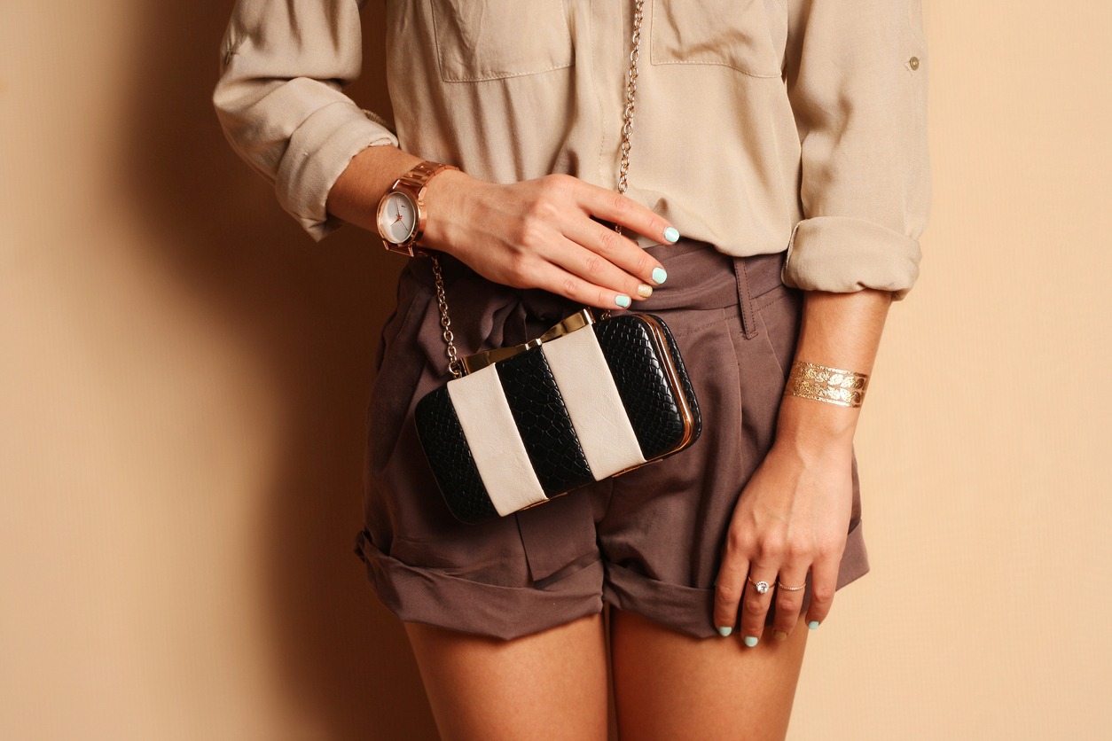 Fashionable woman with stylish black and white clutch