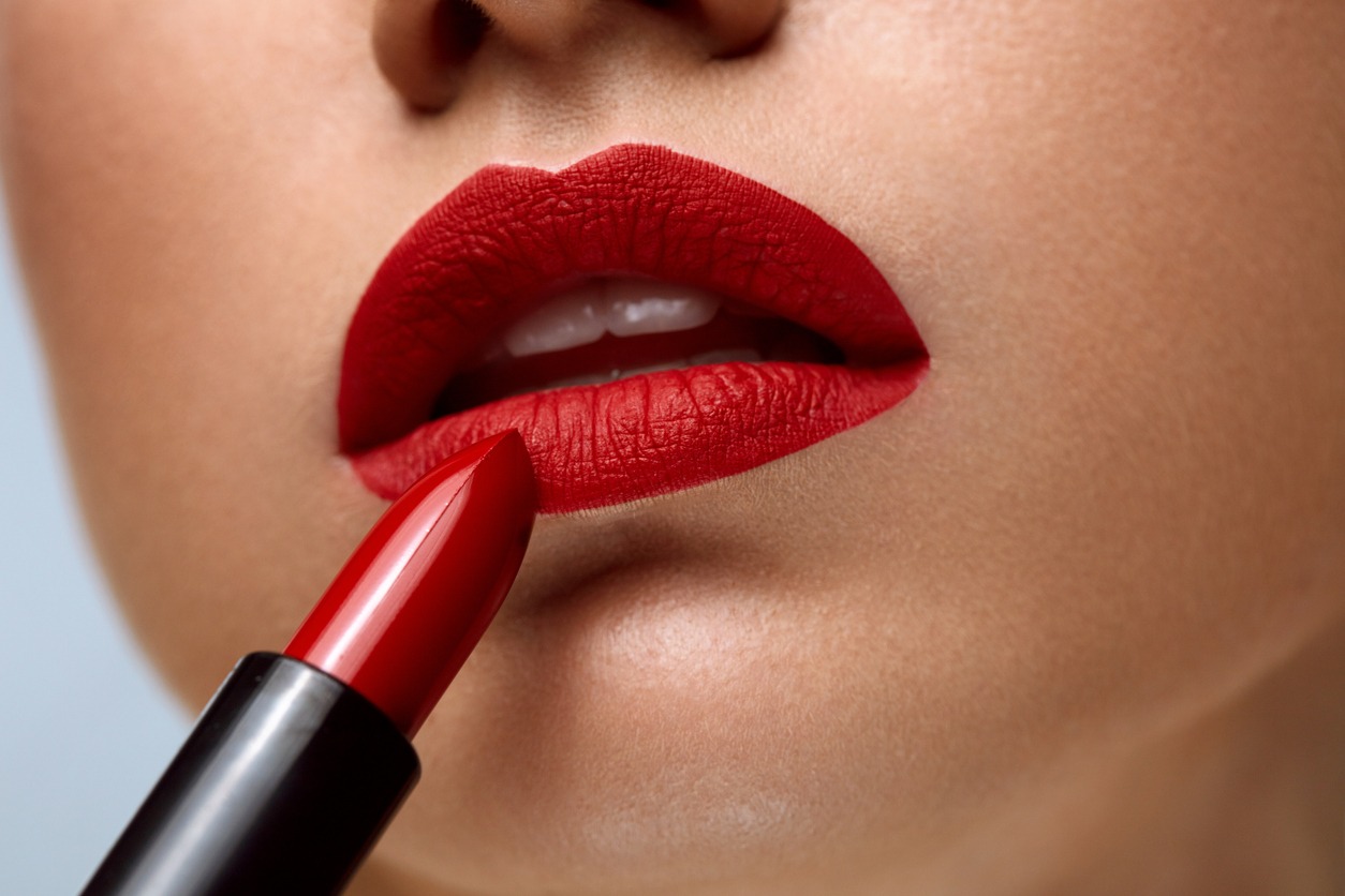 A woman face with bright red matte lipstick on full lip