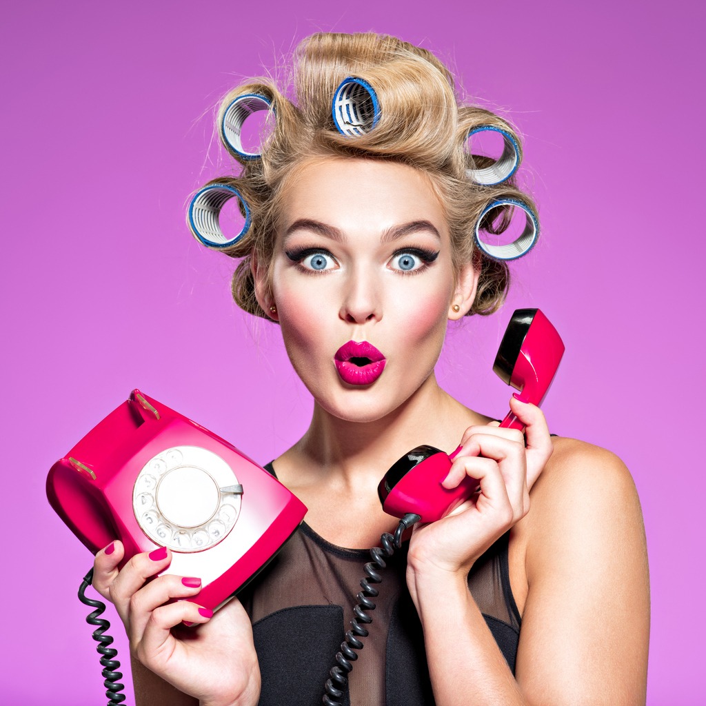 young woman with wonder face holds retro phone