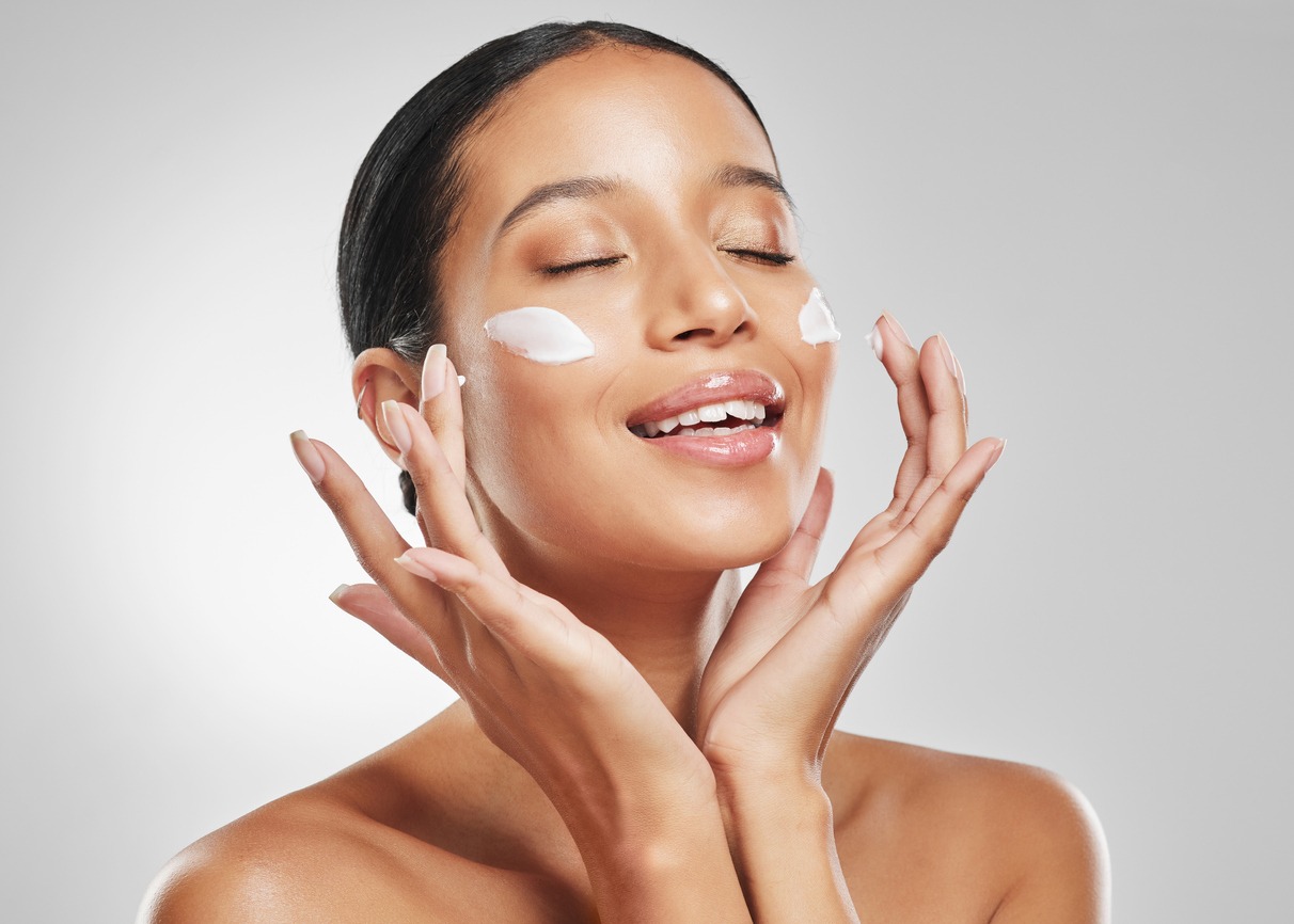 Studio shot of an attractive young woman posing with moisturizer on her face