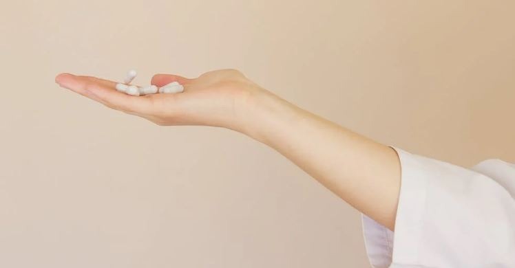 White pills on a woman’s hand