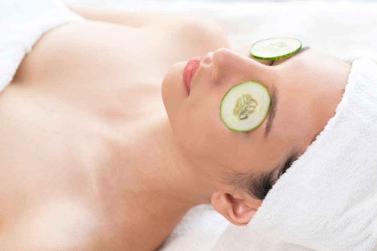 Woman getting eye nature treatment by cucumber