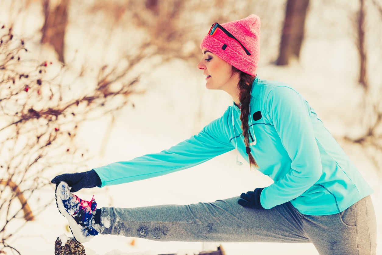 woman drinking water after a workout on a winter day
