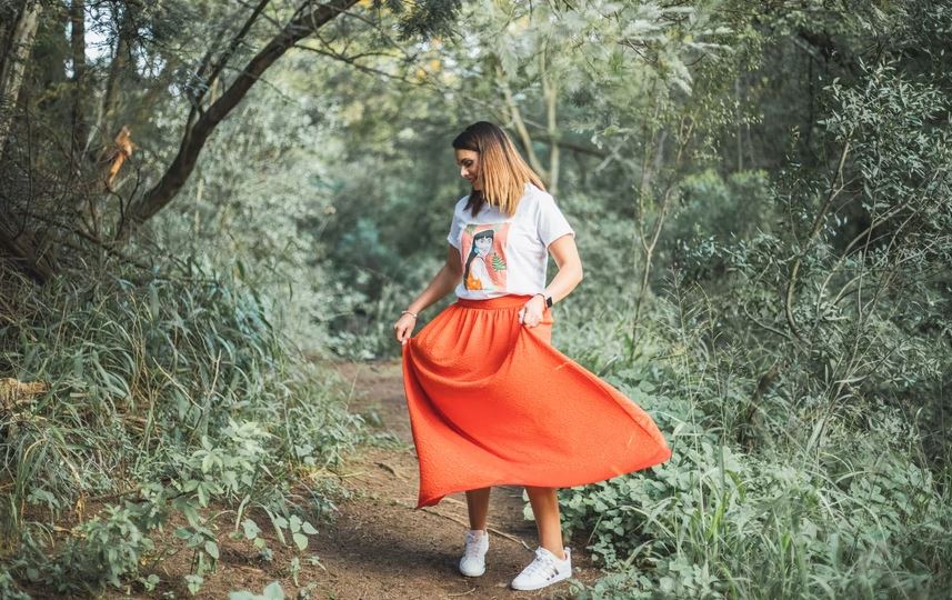 woman wearing a long, orange gathered skirt