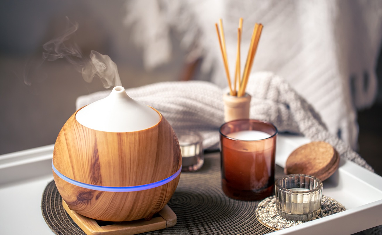 A cozy composition with an aroma diffuser and candlers in a home interior