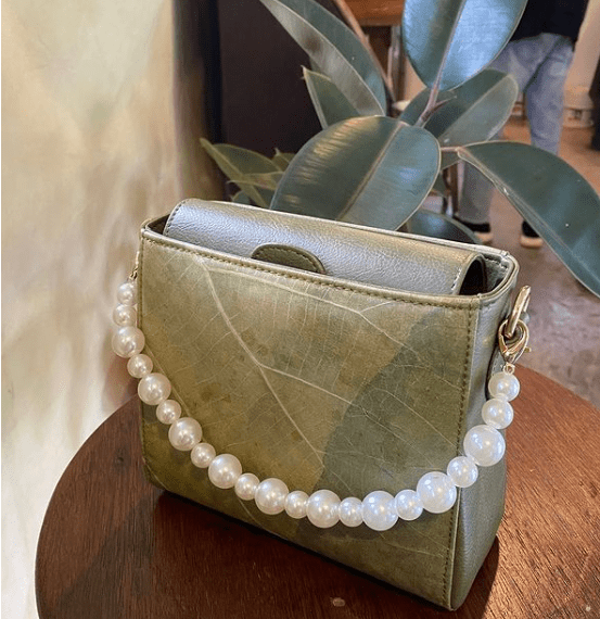 A crossbody bag made of leaf leather with pearl strap