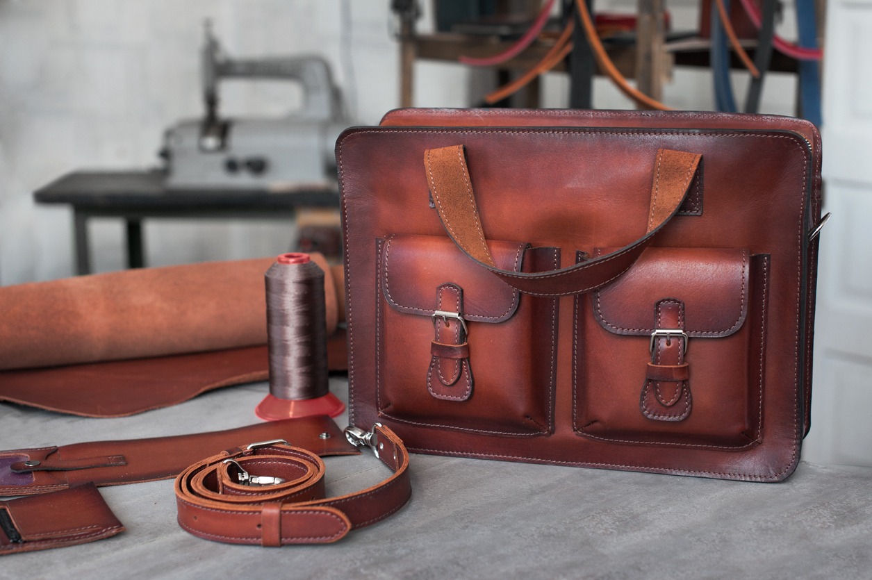 A leather bag and a leather belt in a craft workshop
