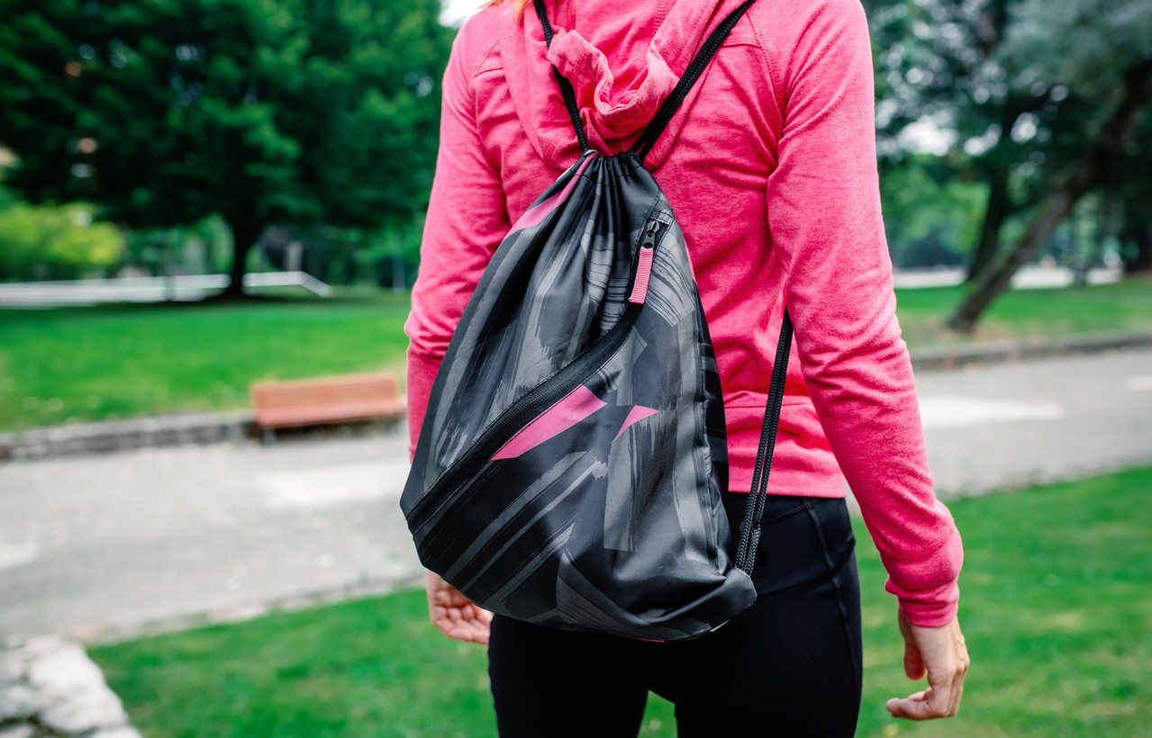 A woman wearing a polyester drawstring backpack for the gym