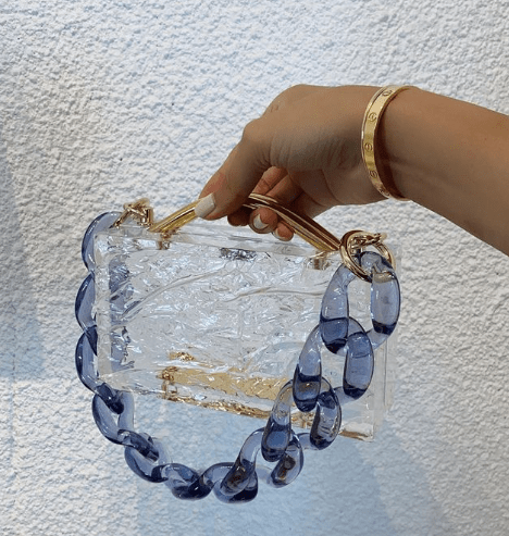 An acrylic handbag with a blue lucite chain