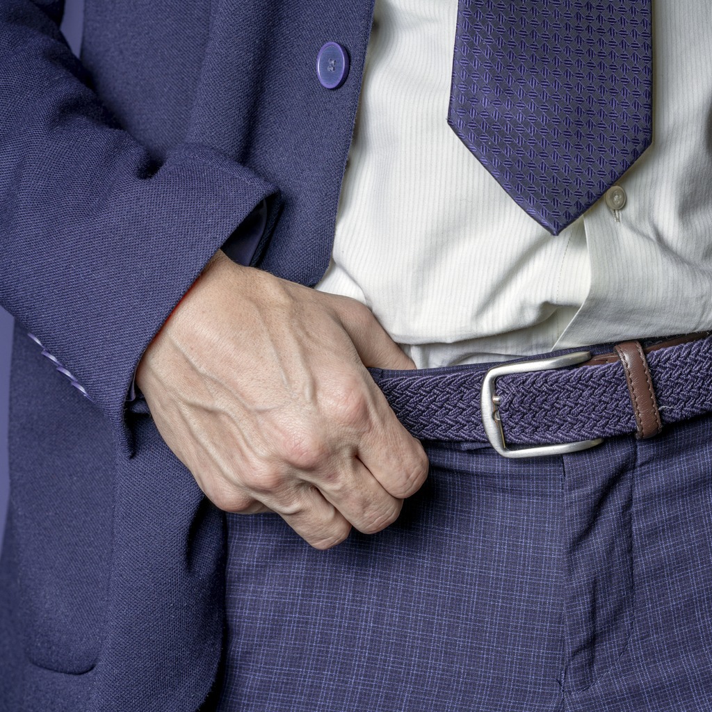 Businessman holding the belt on his trousers