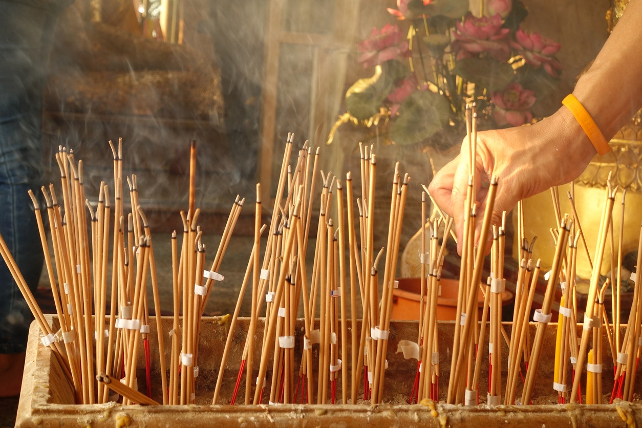 Man holding traditional incense sticks 