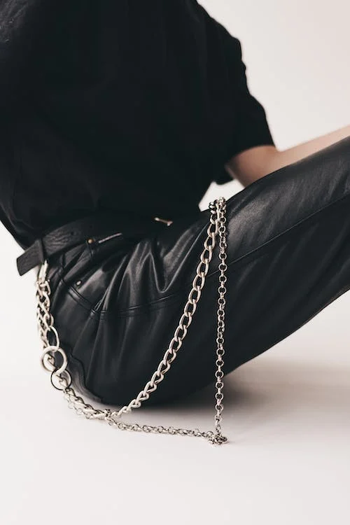 Metal chain belt on leather pants
