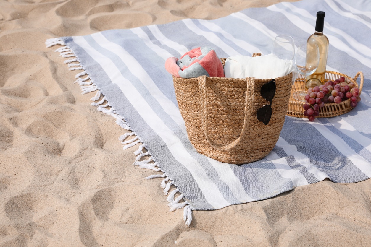 Wine, a bag, and other supplies are needed for a beachside picnic.