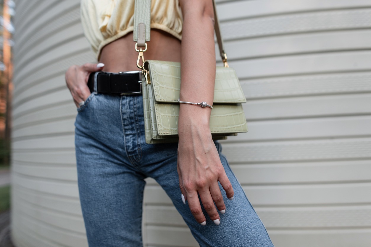 Woman with leather handbag and blue jeans with belt
