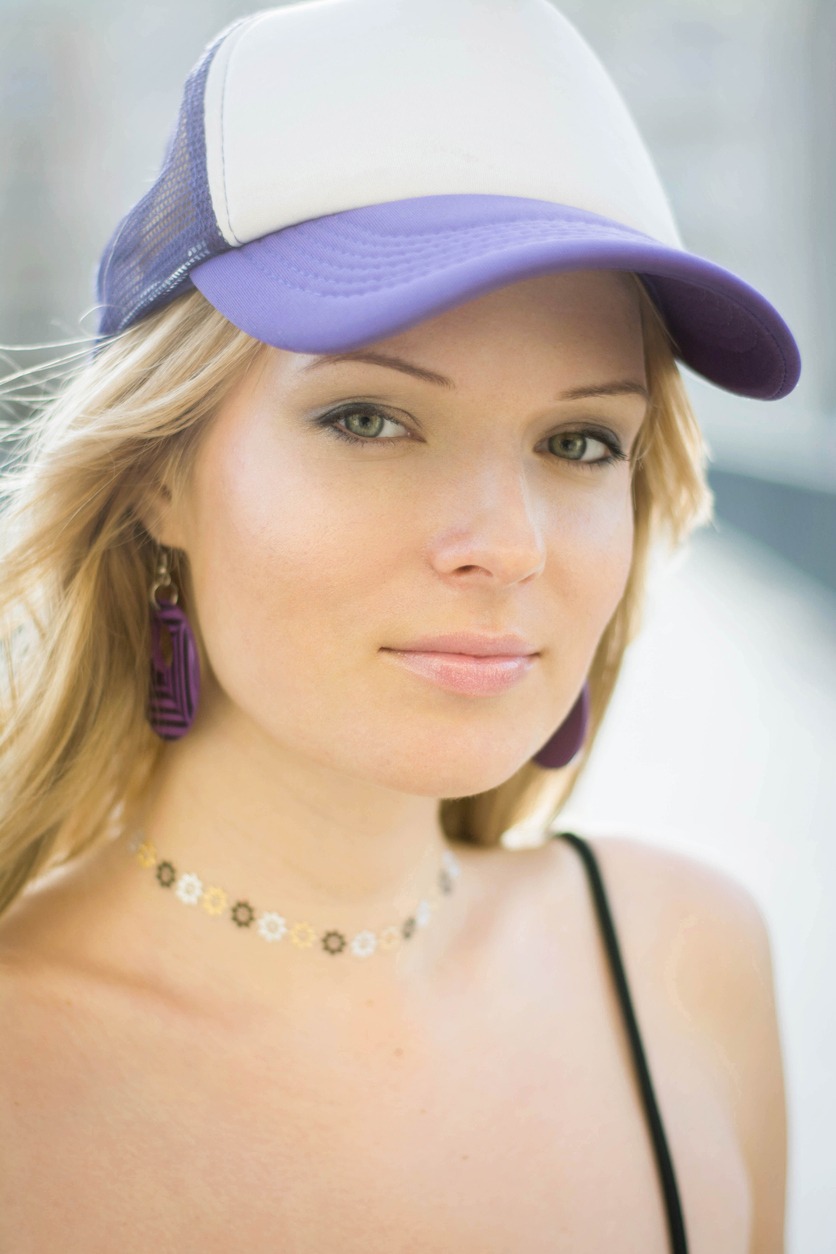 a close up of a woman wearing a white and purple tucker hat