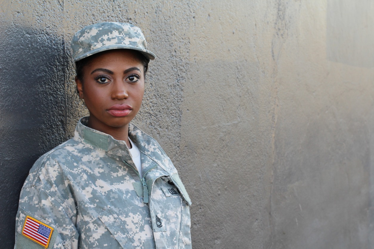 a female American soldier wearing her military uniform including the military hat
