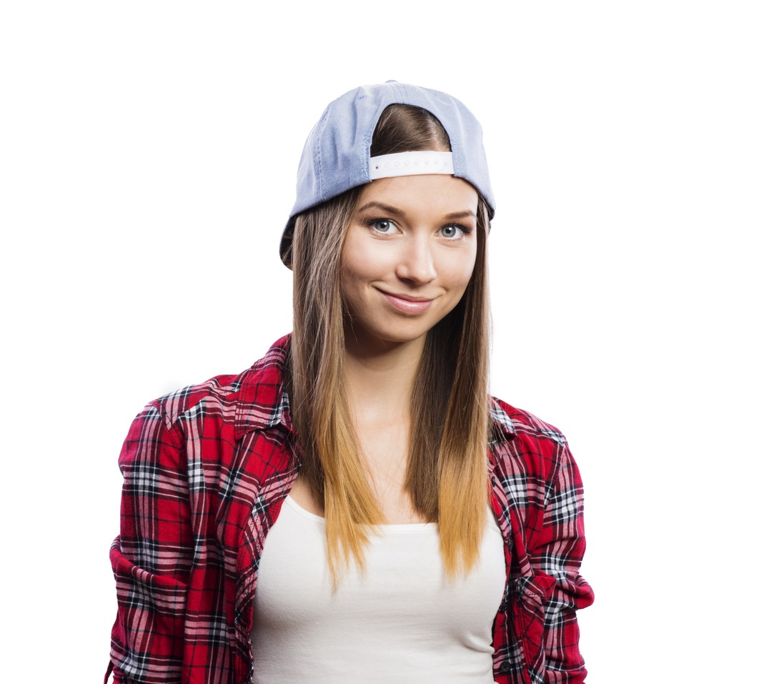 a woman wearing a flannel and a snapback hat backwards