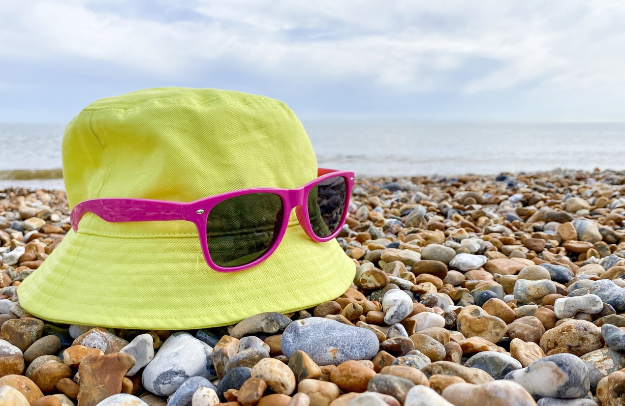 Hat with glasses on the beach