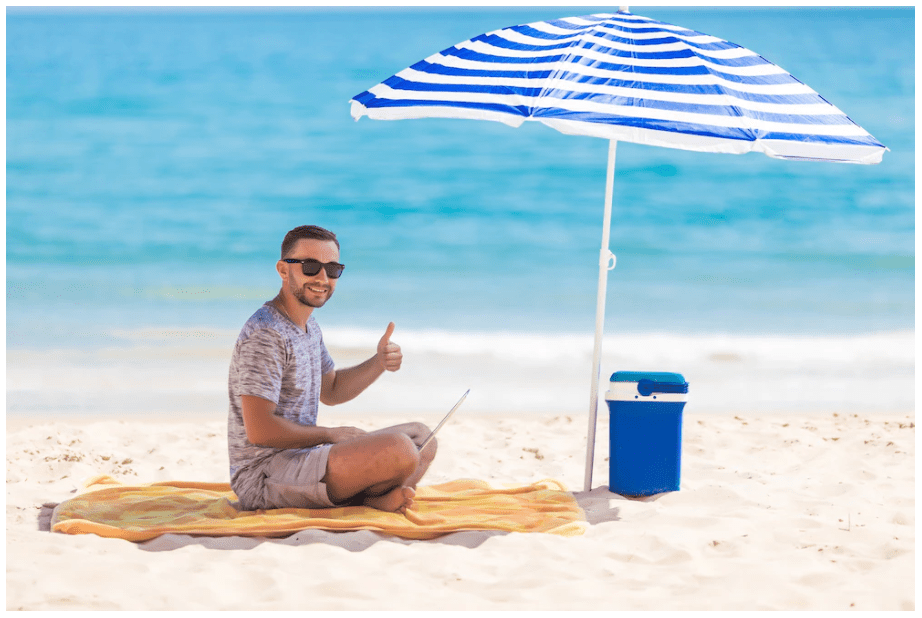 man in a beach under the shade of an umbrella
