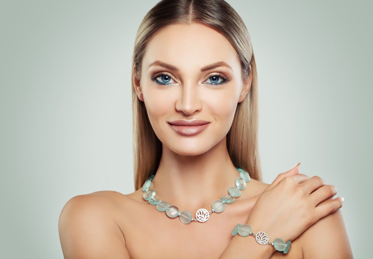 Smiling Woman Fashion Model with Makeup and Jewelry. Silver Necklace and Bracelet with Semiprecious Stones