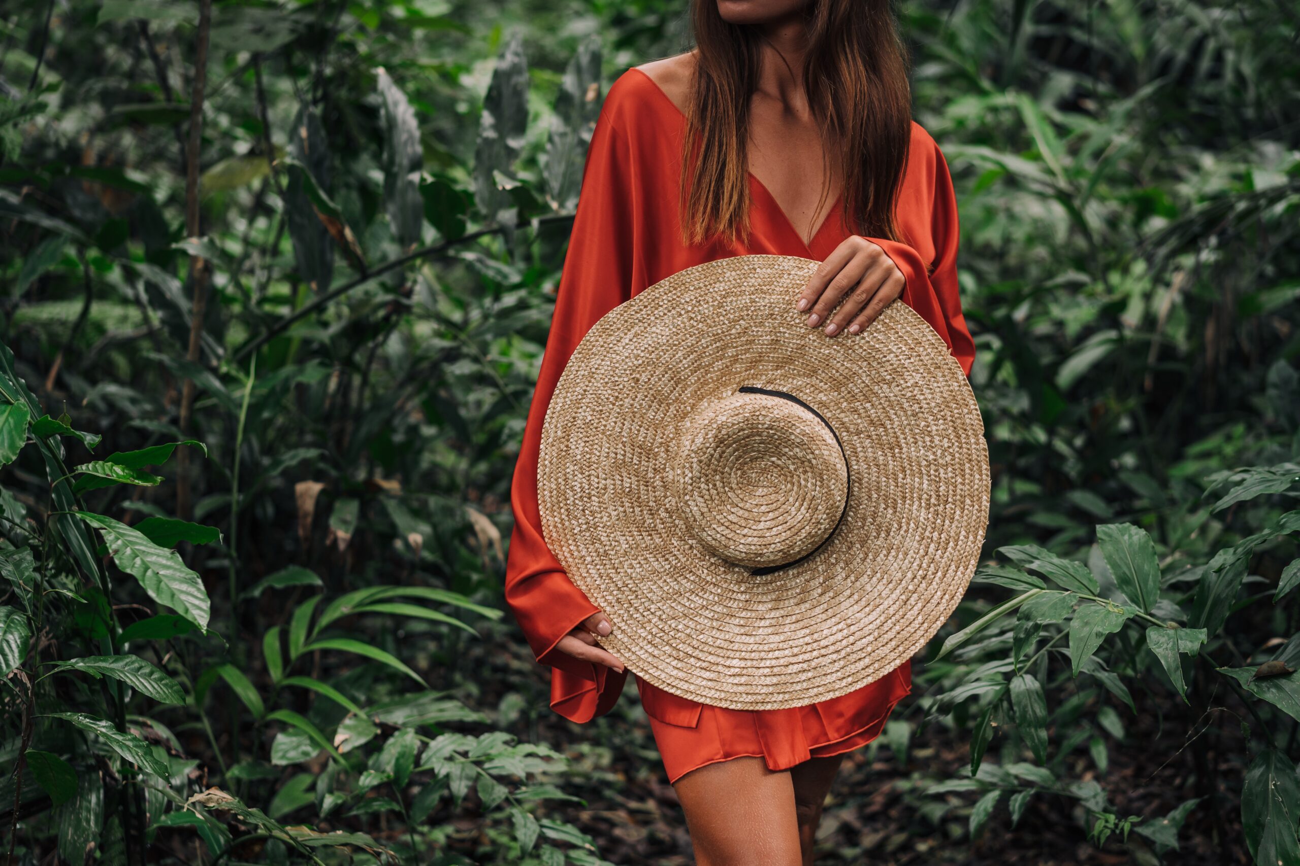 woman holding a large sun hat