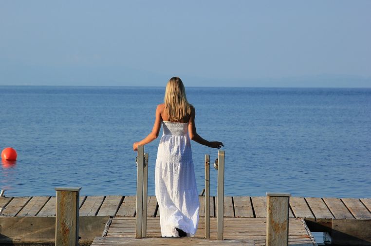 woman-wearing-a-long-white-sun-dress-at-the-beach