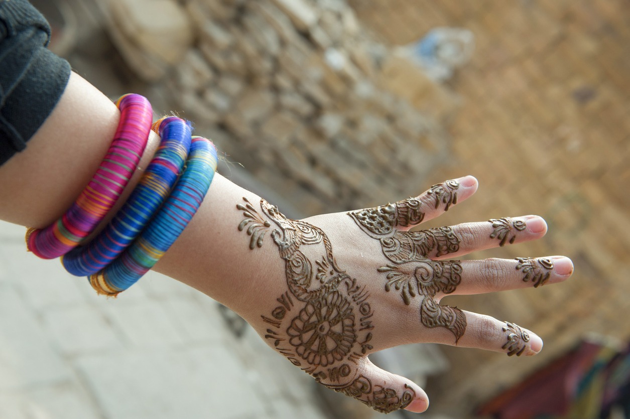woman with an Indian-inspired henna tattoo on her left hand