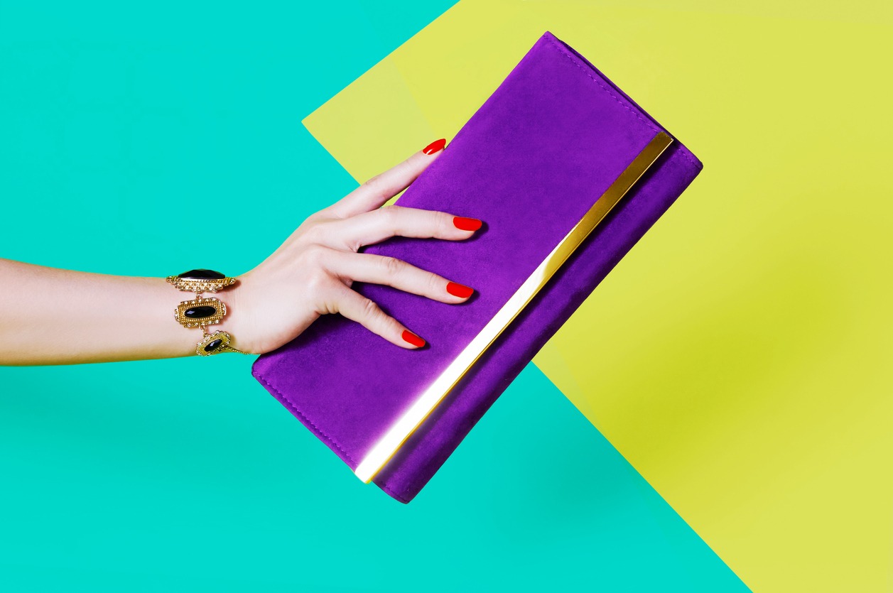 Woman's hand holding purple purse