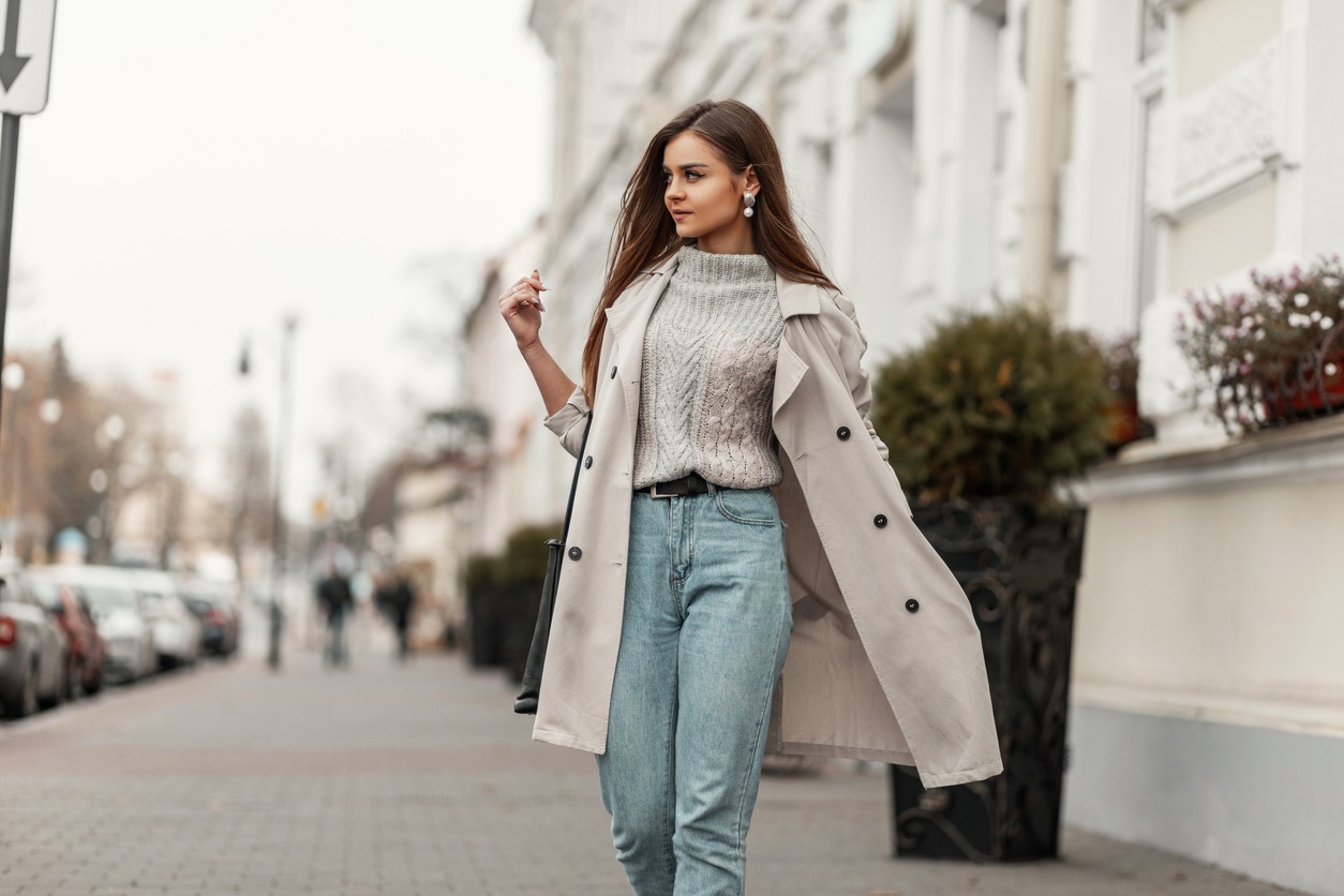 young woman walking on the street wearing trench coat