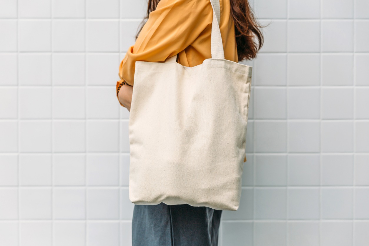 A blank canvas bag on a woman’s shoulder