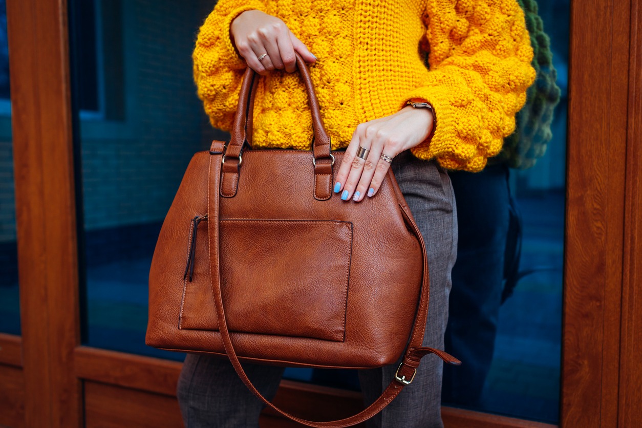A woman carrying a brown leather handbag