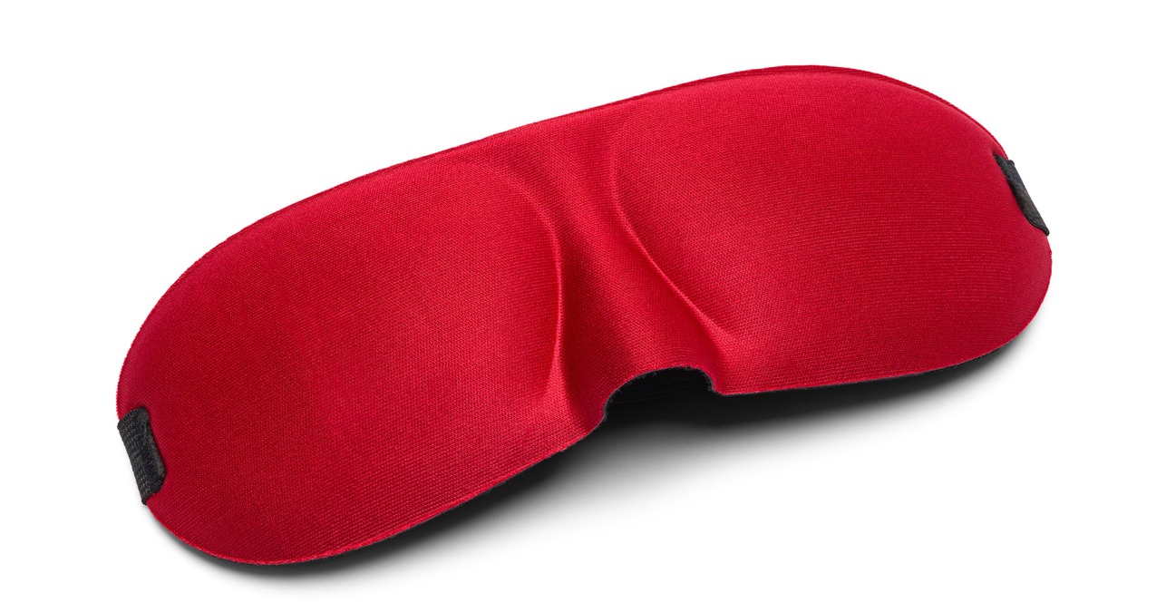 Red silk eye mask against a white background