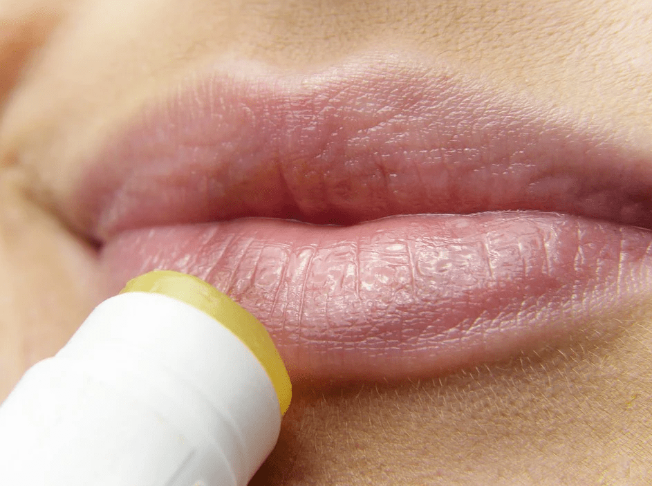 a-woman-applying-a-lip-balm-on-her-lips