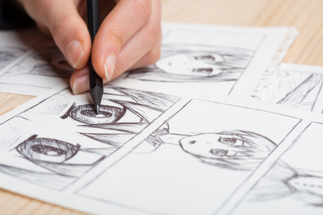 Artist drawing an anime comic book in a studio