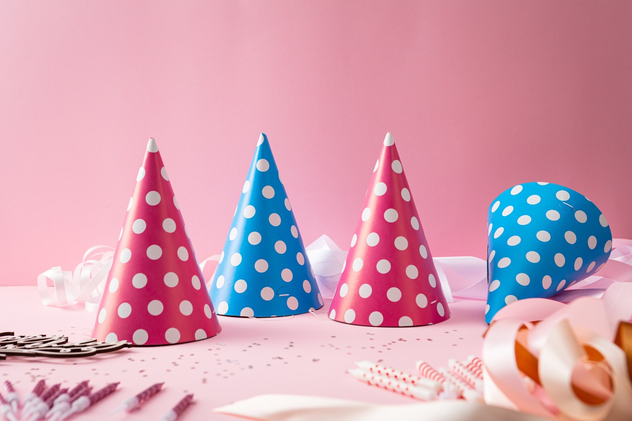 blue and pink polka dotted party hats on a table with other party decor