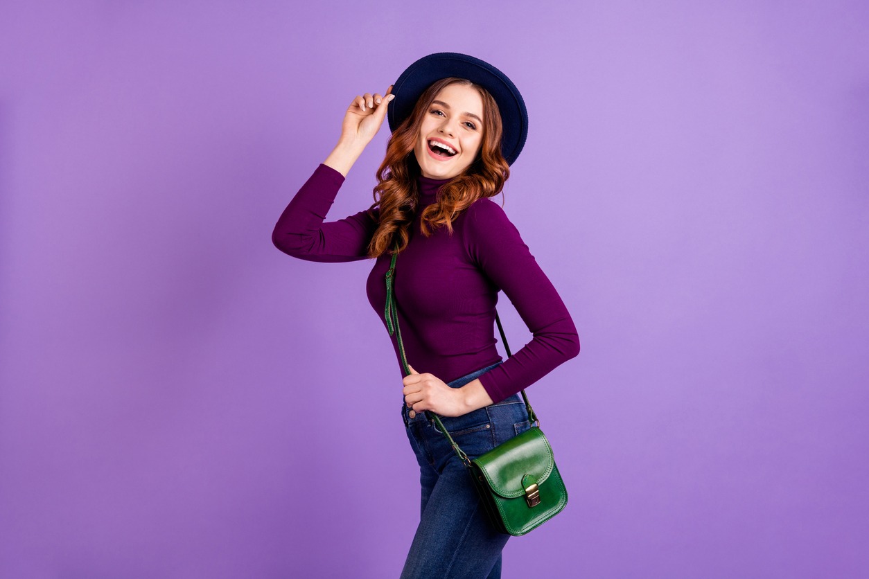 Portrait of charming girl touch hands fingers hat laugh isolated over purple violet background